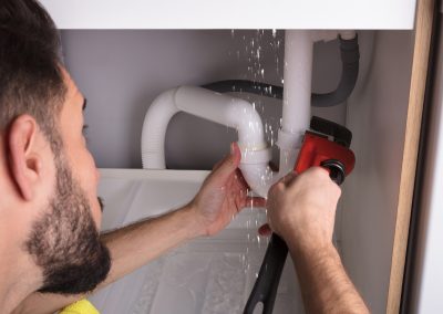 A plumber fixing a leaking pipe| Drain Cleaning Ocala FL