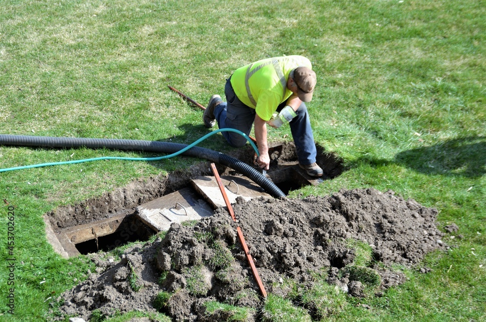 A man inspecting a sewage system | Septic Tank Service
